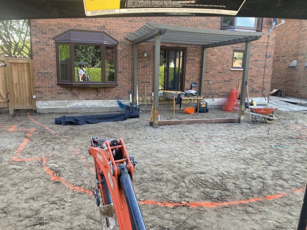 Backyard landscaping and pergola construction in progress following residential pool removal project