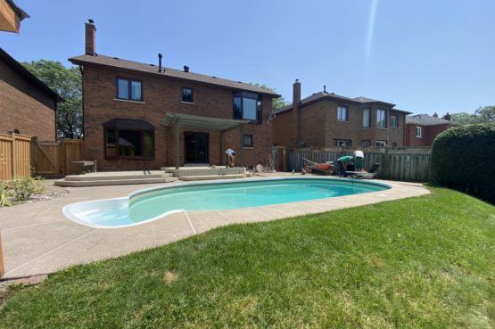 Finished backyard landscaping project with restored lawn, patio, pergola, and swimming pool at residential property