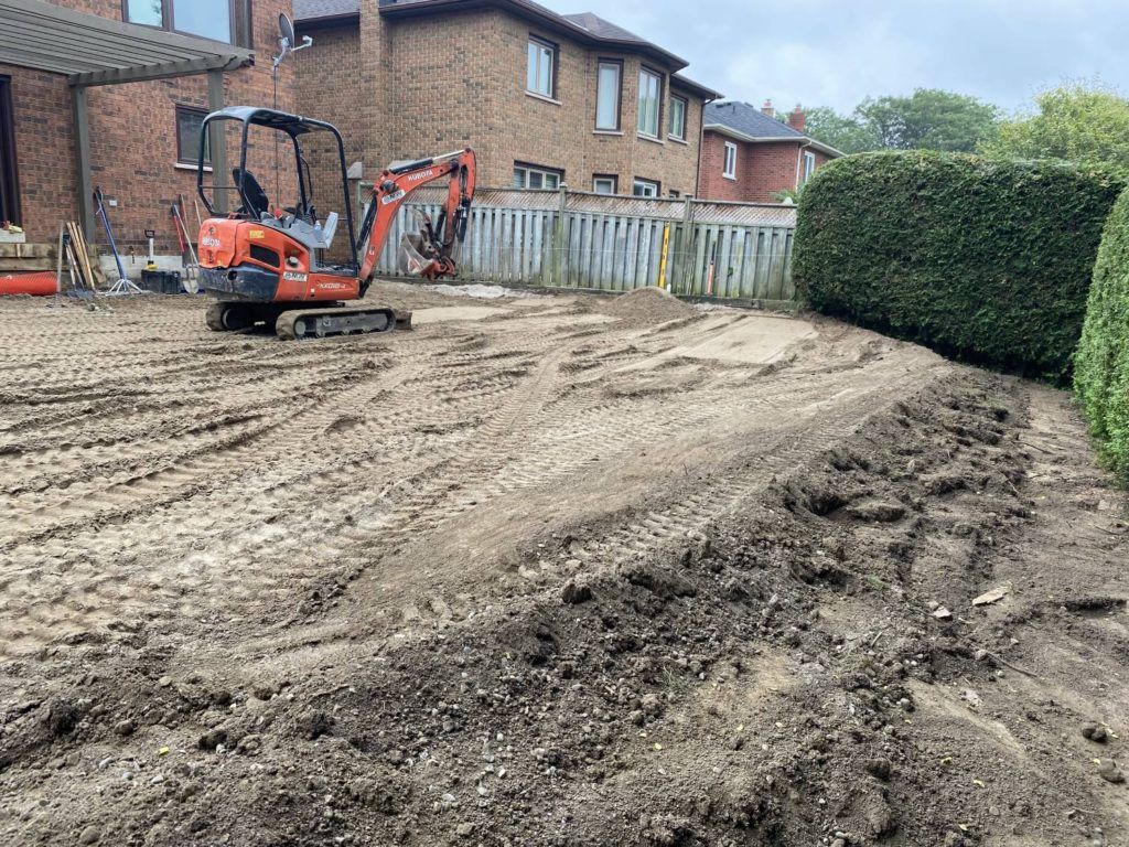 an exavator levelling sand after a pool removal project