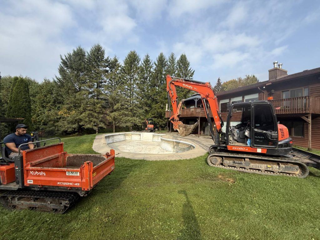 an excavator in the process of demolishing a pool