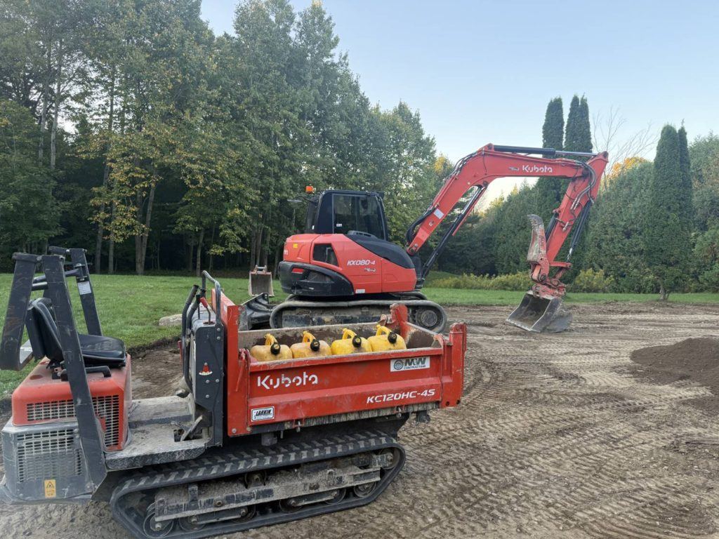 Kubota excavator and tracked dumper during backyard grading after residential pool removal project