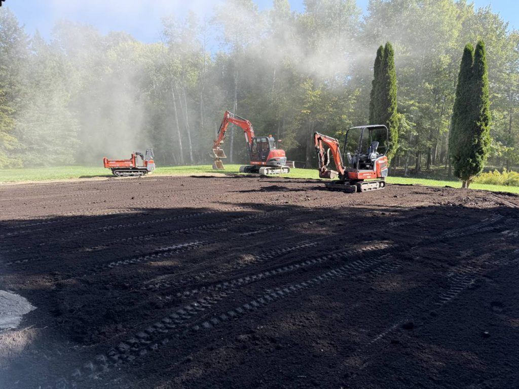 Kubota excavators grading and leveling backyard after residential pool removal project