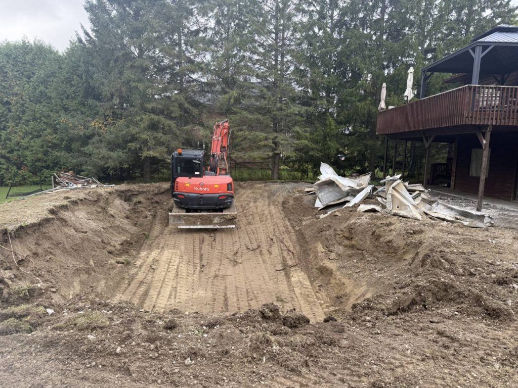 Kubota excavator in backyard during full inground pool removal and excavation project