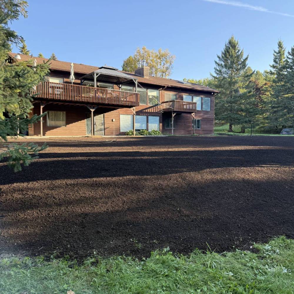 a large patch of dirt in front of a double storey house