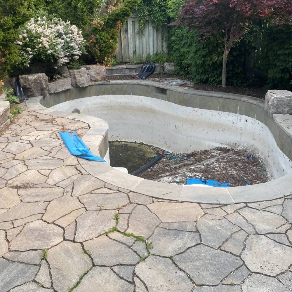 a mainly empty pool surrounded by flagstones
