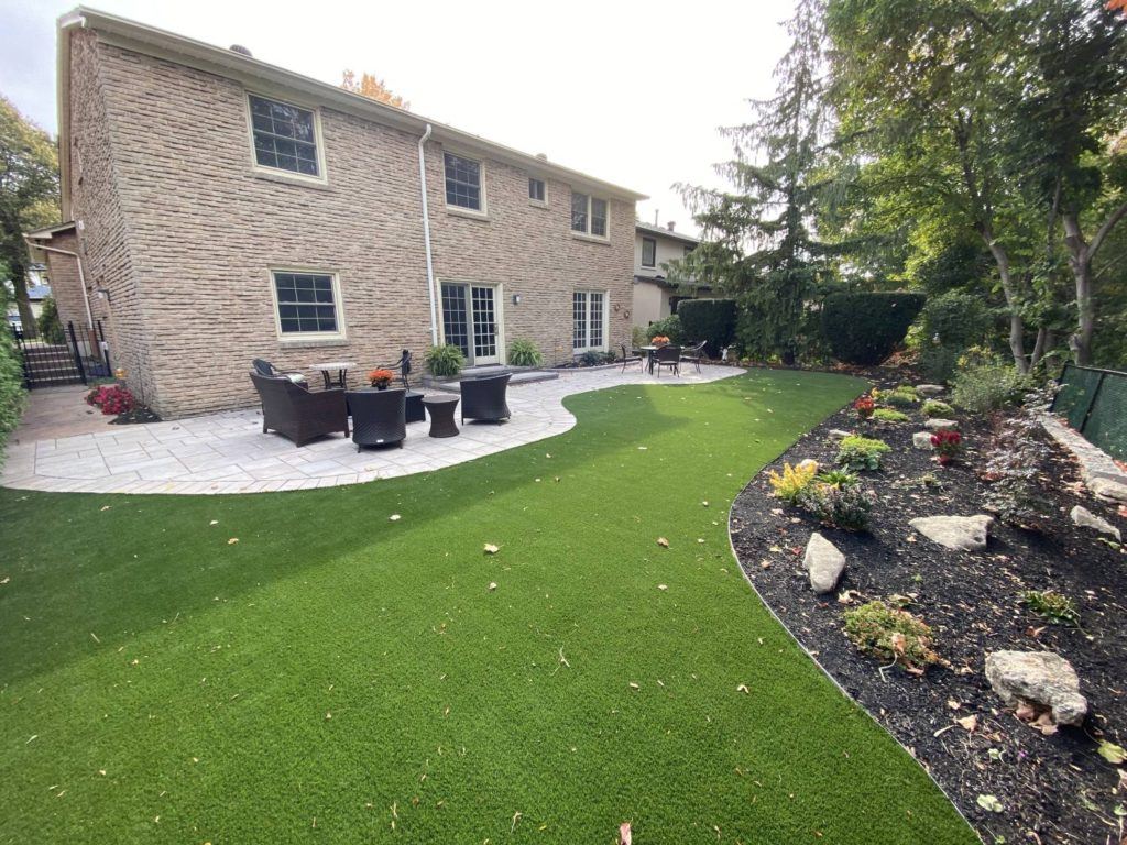 Landscaped backyard with patio and artificial turf after residential pool removal project