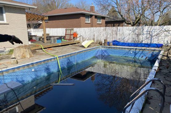 water being pumped out of an inground swimming pool