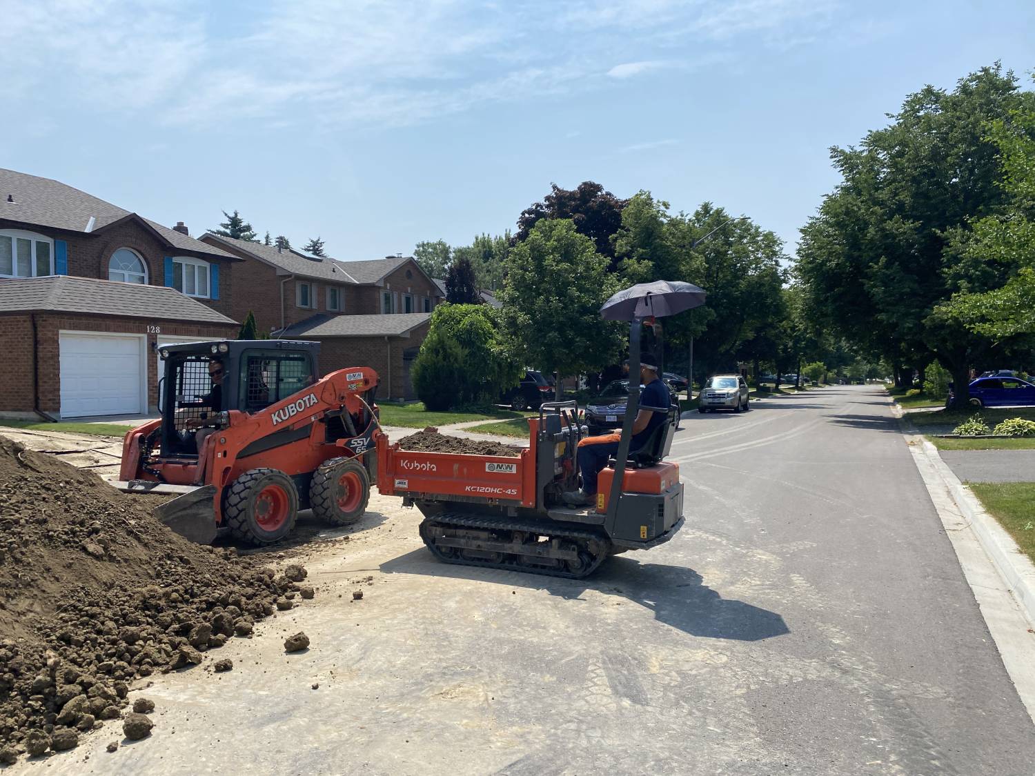 sand being loaded from a pile into a kubota